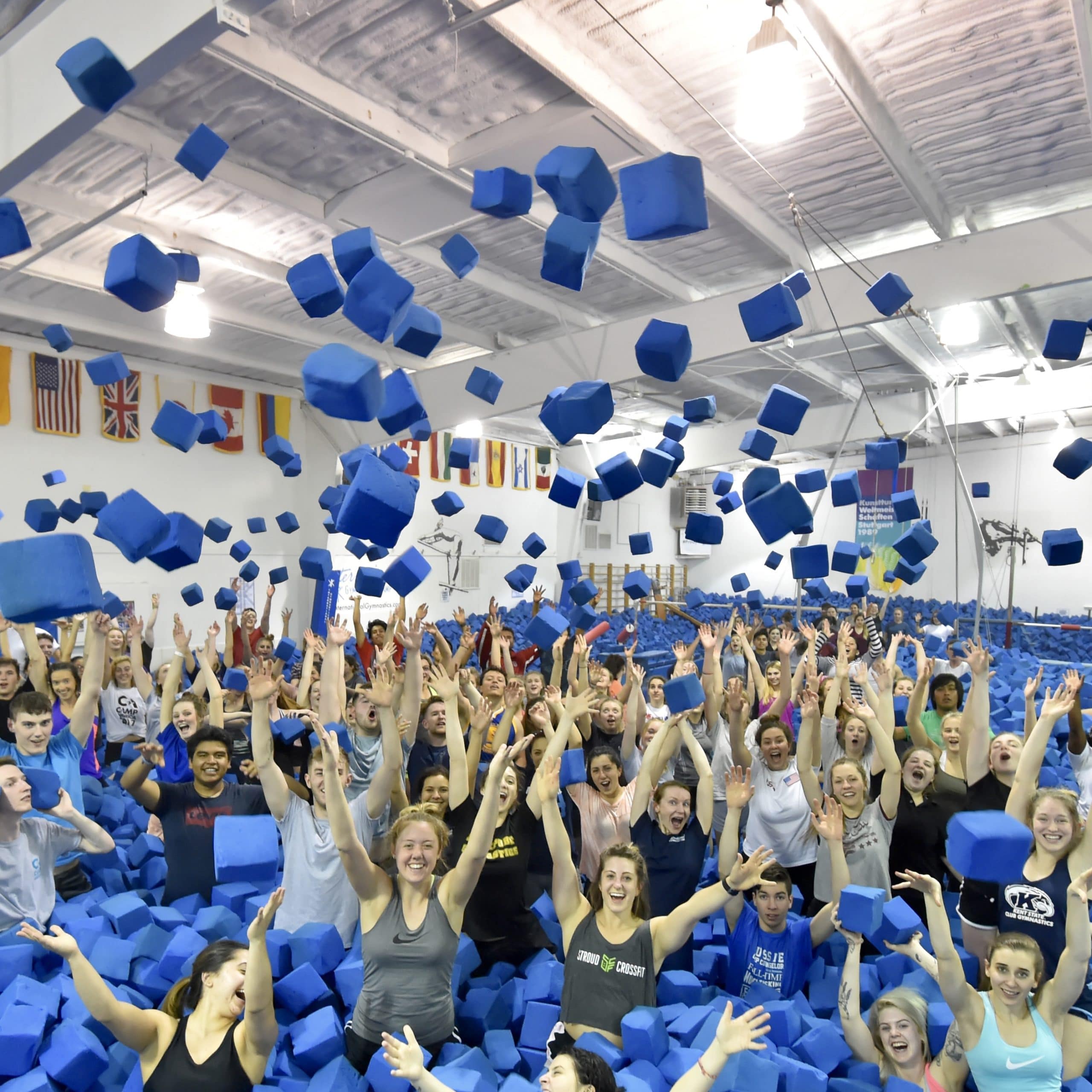 Big group of staff throwing blue blocks into the air