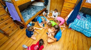 campers and counselors sitting in a circle on the floor of a cabin