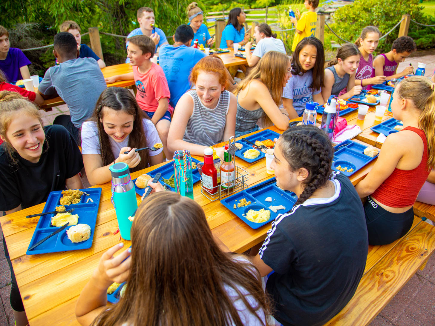 children laughing and eating at picnic tables
