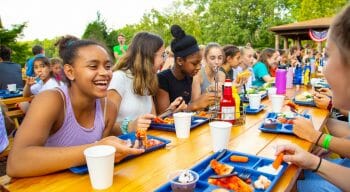 group of young girls eating at picnic tables