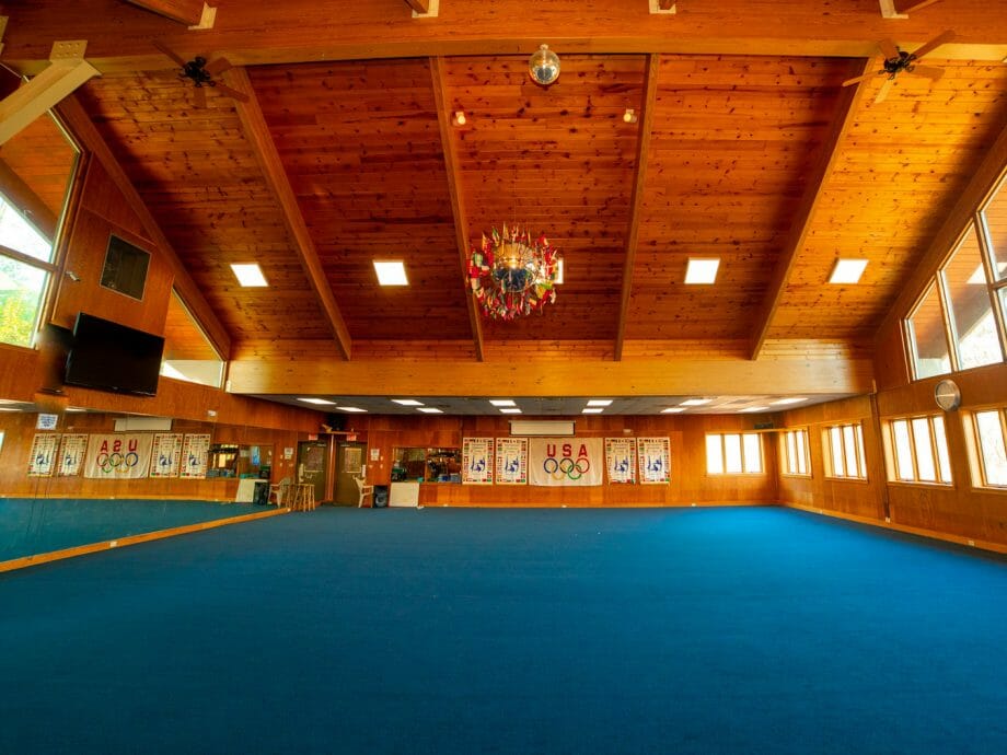the wide open floor gym with log cabin style ceiling