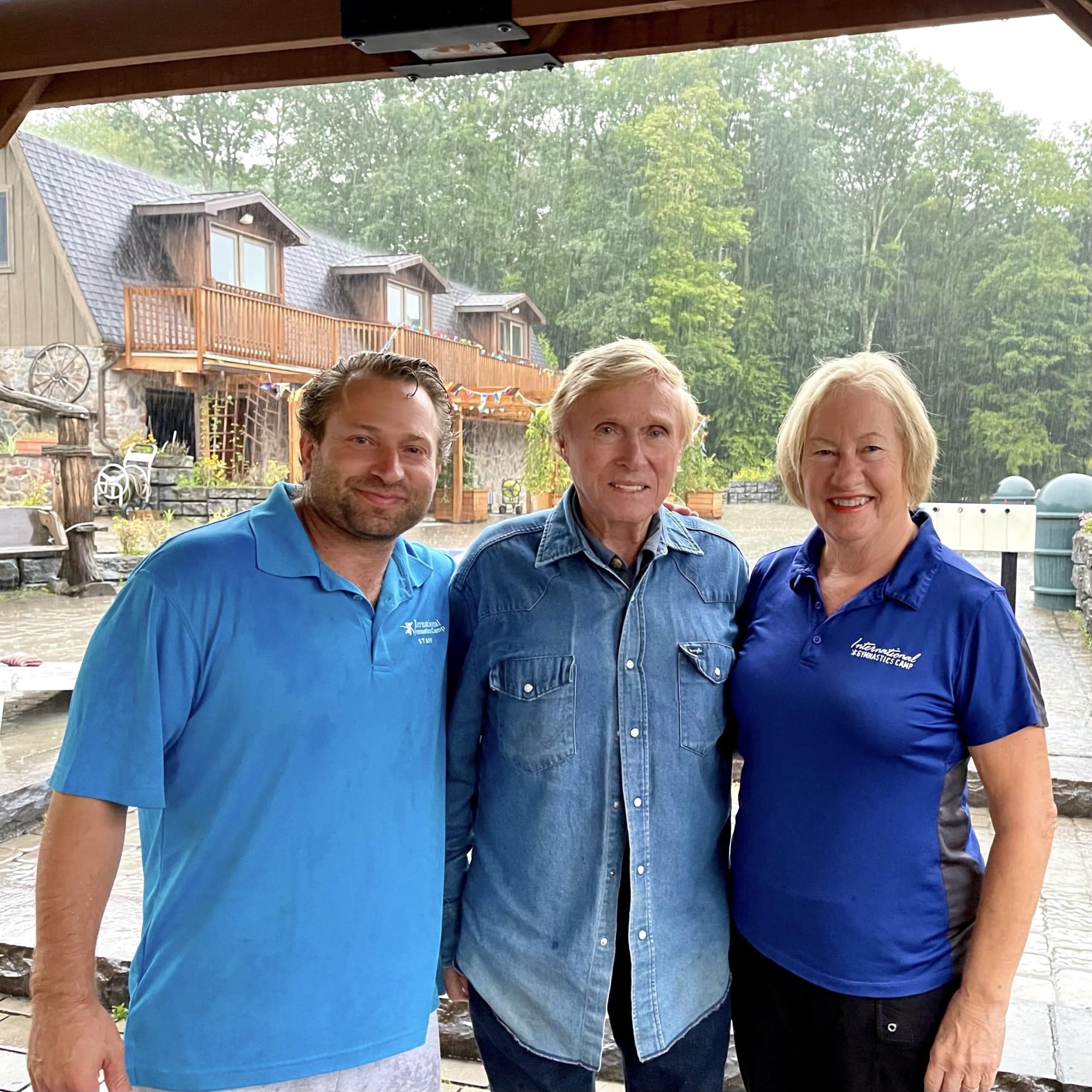The people, IGC owners and directors, pose for a photo in front of a camp building.