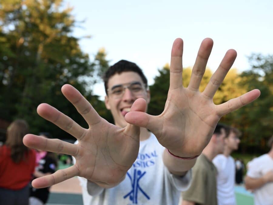 A male poses with his hands in front of his face, in the shape of the Kount on Kindness logo.