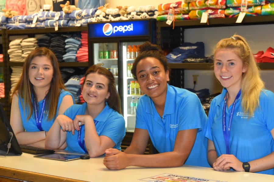 4 young women standing at counter in IGC gear
