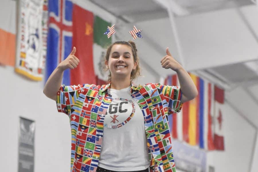 a staff member proudly displays multiple country flags from around the world.