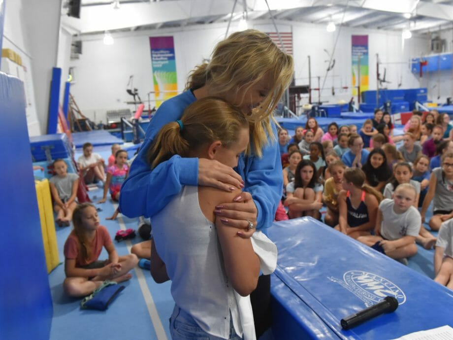 candid photo of Nastia Liukin hugging a camper