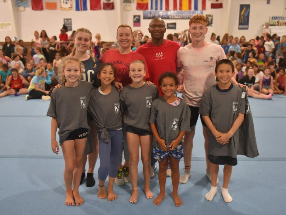 group of campers posing with their instructors in the olympic gym