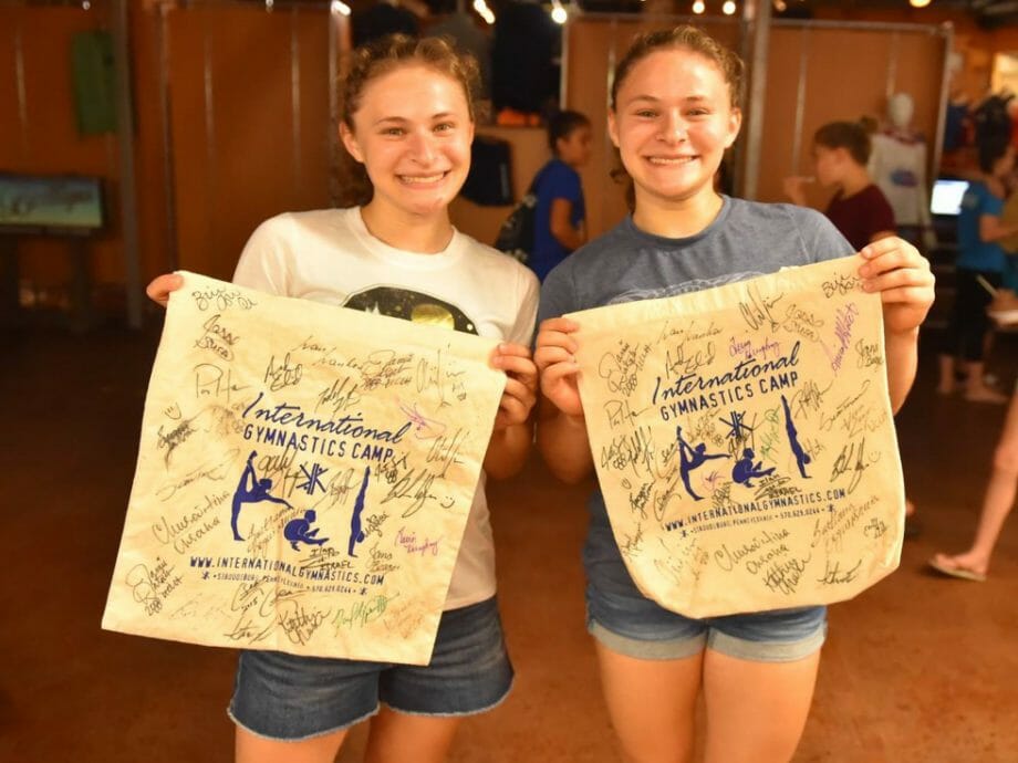 two campers holding their IGC pennants with signatures from celebrity guests